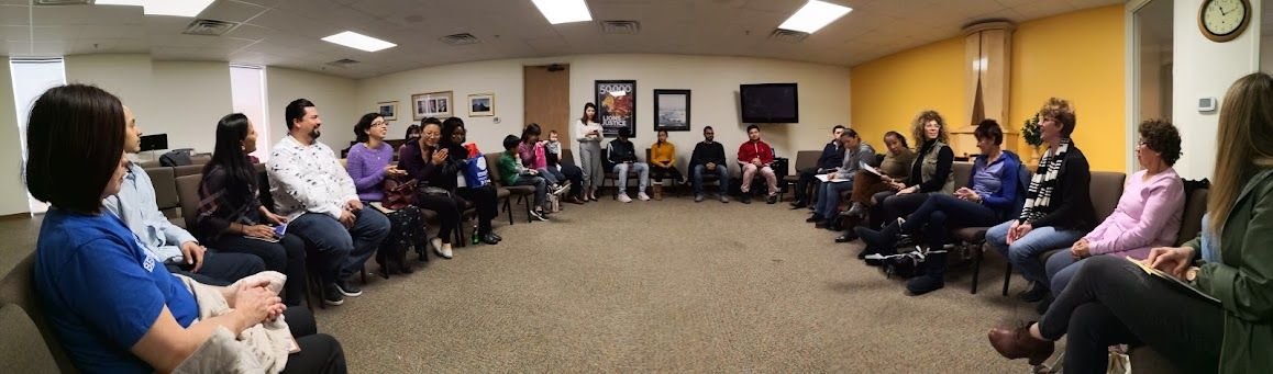 Members and guests seated in a circle at a discussion meeting